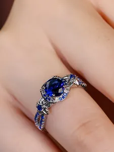 Macro view of blue stone ring with floral filigree and small pave-set diamonds