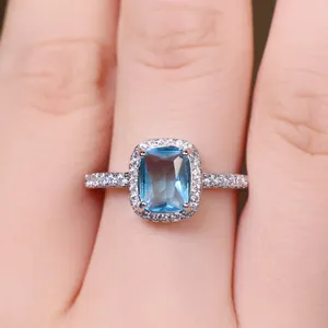Macro shot of a rectangular blue gemstone ring with micro-pave diamonds on silver band
