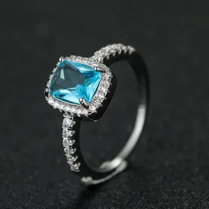 Macro view of rectangle blue stone ring with halo diamonds and adjustable silver band