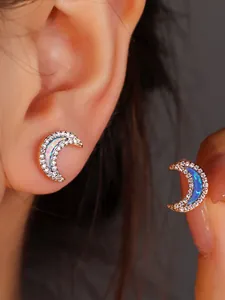 Macro detail of crescent moon earrings in rose gold with opal inlay and zircon stones