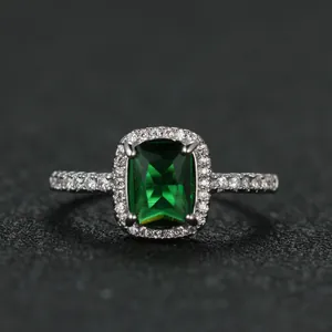 Macro view of emerald-cut green gemstone ring with white gold plated pavé setting