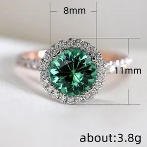 Dettaglio macro di un anello di lusso con gemma verde da 8mm e halo di diamanti oro rosa