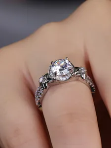Detailed close-up of a luxury four-prong round solitaire ring with intricate leaf motif