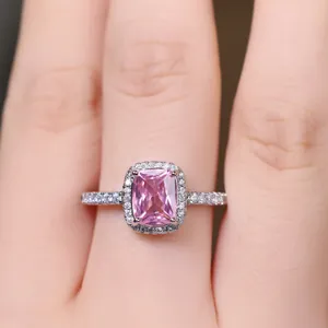 Macro shot of a pink rectangular cushion-cut halo ring with micro-paved white diamonds