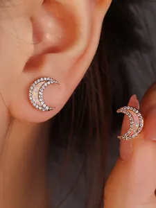 Close-up of crescent moon opal stud earrings with white zircon accents in rose gold finish