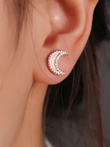 Detailed close-up of rose gold crescent moon earrings with pink opal inlay and zircons