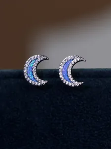 Macro shot of silver crescent moon earrings with blue opal and white cubic zirconia