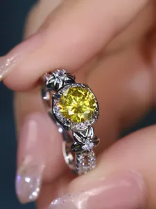 Detailed macro view of yellow gemstone ring with intricate floral design and diamond accents