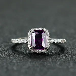 Macro detail of radiant cut purple gemstone ring with halo diamonds on silver band