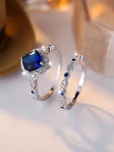 Macro detail of silver square blue gemstone ring set with sparkling side diamonds