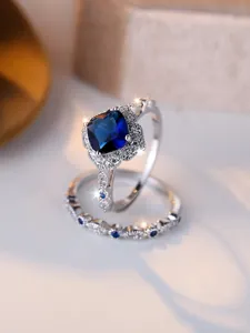 Detailed shot of silver square blue sapphire ring set with sparkling side diamonds
