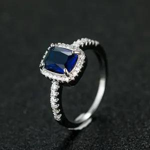 Macro shot of rectangular blue gemstone ring with micro-pave diamonds in white gold plating