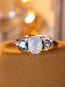 Close-up of oval opal ring with heart-shaped colorful stones and silver setting