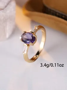 Dettaglio anello dorato vintage con gemma viola e pietre laterali baguette, 3,4 g