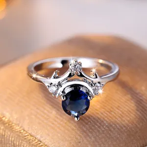 Elegante anello a corona in argento con gemma blu scuro e dettagli in diamante