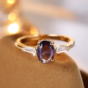 Elegante anello d'oro con gemma viola ovale e diamanti laterali su portagioielli