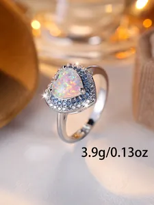 Gros plan détaillé d'une bague opale en forme de cœur avec pierres bleues et blanches