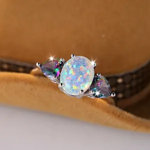 Elegant silver three-stone ring with oval white opal and colorful pear-cut gemstones