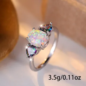Three-stone ring with oval white opal center and colorful heart-shaped side stones