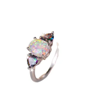 Elegant sterling silver ring with oval white opal and two heart-shaped mystic topaz stones
