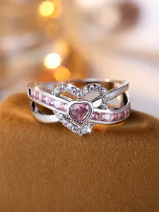 Macro detail of silver ring with double heart structure and pink heart gemstone