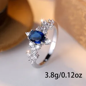 Elegante anello d'argento con gemma blu ovale e accenti di zirconi cubici