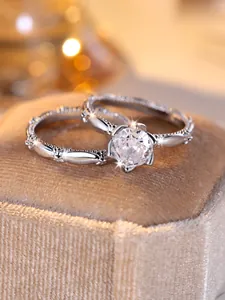 Macro shot of silver stacking rings with round white zircon in a velvet gift box