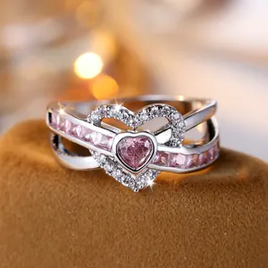 Silver-tone heart ring with pink gemstones and zircon accents on a velvet base