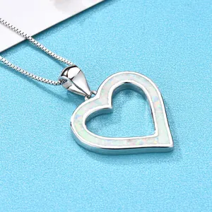 Elegant heart-shaped opal pendant necklace in polished silver on a blue background