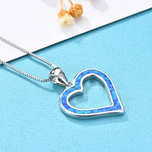 Detailed close-up of a silver heart pendant featuring a vibrant blue opal inlay