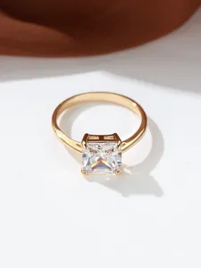 Κοντινό πλάνο ζιργκόν κοπής princess με χρυσή βάση τεσσάρων δοντιών