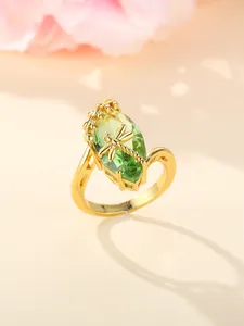 Macro detail of golden dragonfly ring with large marquise olive green gemstone