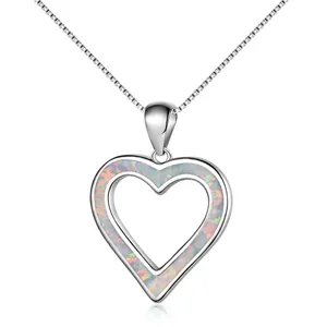 Macro shot of silver heart pendant with iridescent opal inlay on a box chain