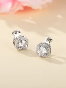 Macro detail of silver stud earrings with large central zircon and octagon halo setting