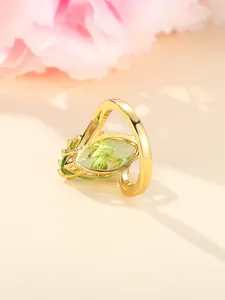 Macro detail of gold vintage ring featuring green marquise gemstone and filigree