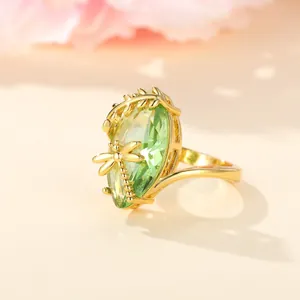 Vintage gold ring featuring a large green marquise gemstone and a delicate dragonfly detail
