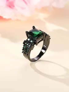 Macro detail of vintage black ring featuring large square green zircon and paved side stones