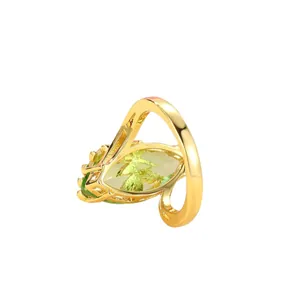Artistic gold-finished ring with large marquise-cut olive green gemstone on white background