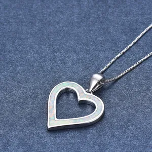Macro shot of silver heart pendant with vibrant blue opal inlay on a box chain