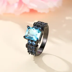 Modern black gold ring with emerald cut blue zircon and micro-pave side stones