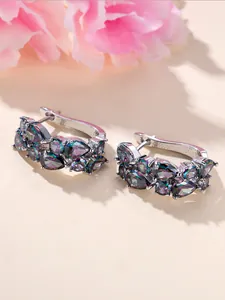 Detailed macro view of silver hoop earrings with multicolored teardrop-shaped zircons