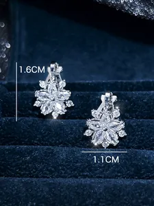 Detailed view of silver flower ear clips with white zircons, size 1.6cm by 1.1cm