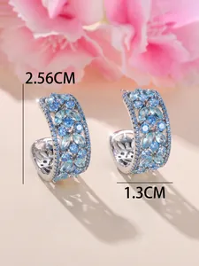 Vue détaillée des boucles d'oreilles en C avec cristaux bleus et dimensions