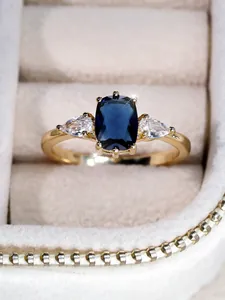 Vue détaillée d'une bague vintage en or avec saphir et zircons dans un écrin en velours