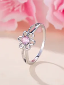 Detailed close-up of a silver flower ring with pink gemstone and hollowed-out petals