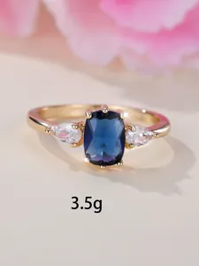 Vue macro d'une bague à trois pierres avec saphir bleu taille coussin et pierres latérales