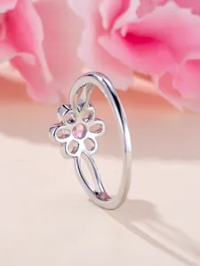 Detailed side view of silver flower ring with pink zircon and intricate hollow structure