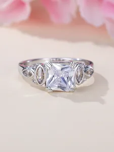 Macro shot of silver ring with large square zircon and marquise cut side stones
