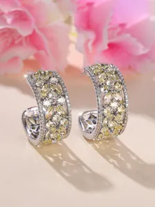 Détails macro des boucles d'oreilles créoles avec zircons jaunes taille marquise
