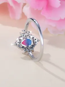 Nahaufnahme der Silberkrone mit birnenförmigem Edelstein im Farbverlauf von Pink zu Blau